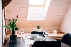 une salle à manger avec une table, des verres et des fleurs dans l'établissement Principia Apartments, à Turda