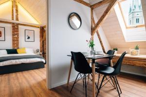 - une chambre avec un lit, une table et des chaises dans l'établissement Principia Apartments, à Turda