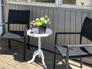 a table with a glass of wine and a vase of flowers at Two-Bedroom Holiday home in Aabenraa 2 in Aabenraa