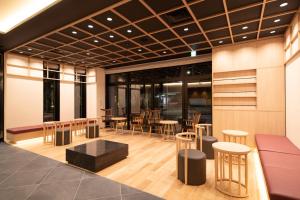 un hall avec des tables et des chaises dans un bâtiment dans l'établissement Almont Hotel Nippori, à Tokyo