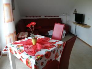 uma mesa com uma toalha de mesa florida e um vaso de flores em cima em Fewo Elbblick im Haus Lühegarten em Grünendeich