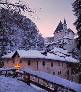 ein Gebäude mit einem Feuer davor im Schnee in der Unterkunft Agritur Piccolo Fiore B&B in Thayl