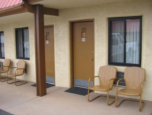 a row of chairs sitting outside of a building at Mecca Motel in Colorado Springs