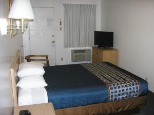 a hotel room with a bed and a television at Mecca Motel in Colorado Springs