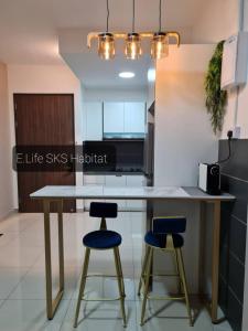 cocina con mesa y 2 taburetes de barra azul en E Life SKS Habitat With WiFi Netflix, en Johor Bahru