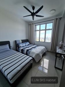 1 dormitorio con 2 camas y ventilador de techo en E Life SKS Habitat With WiFi Netflix, en Johor Bahru