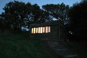 ein kleines Gebäude mit Lichtern auf einem Feld in der Nacht in der Unterkunft Stags View,Unique eco cabin, Dartmoor views in South Brent