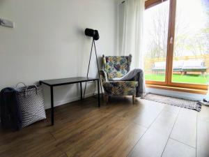 uma sala de estar com uma cadeira, uma secretária e uma janela em Apartman Loggia Park & Free Parking em Žilina