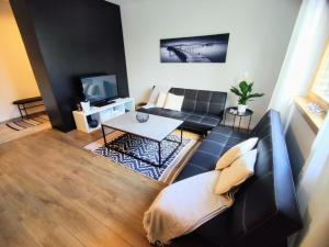 uma sala de estar com um sofá e uma televisão em Apartman Loggia Park & Free Parking em Žilina