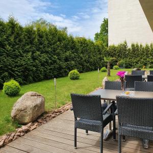 eine Terrasse mit einem Tisch, Stühlen und einem Felsen in der Unterkunft Hotel Atlas Halle in Halle an der Saale