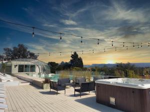 une terrasse avec un bain à remous, des chaises et un bain à remous dans l'établissement Pinares Panorama Suites & Spa, à Villa Carlos Paz