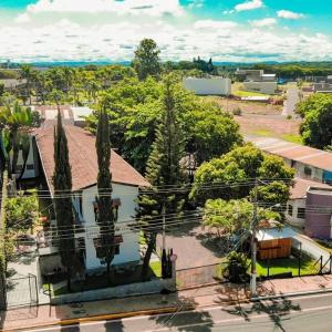 Vistas áridas a una ciudad con un edificio y árboles en Shellter Hotel, en Holambra