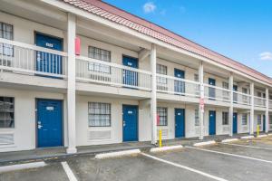 un immeuble d'appartements avec portes bleues dans un parking dans l'établissement Motel 6-Dallas, TX - Market Center, à Dallas