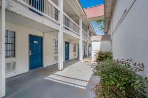 un couloir d'un immeuble d'appartements avec portes bleues dans l'établissement Motel 6-Dallas, TX - Market Center, à Dallas