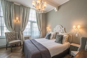 - une chambre avec un grand lit et un lustre dans l'établissement Boutique Hotel Huys van Leyden, à Leyde