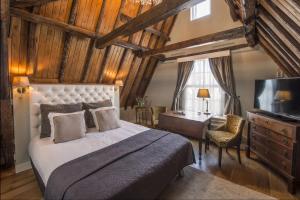 - une chambre avec un lit, un bureau et une télévision dans l'établissement Boutique Hotel Huys van Leyden, à Leyde