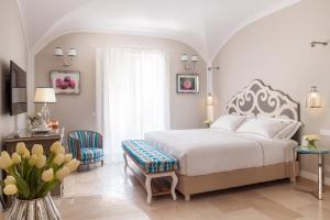 1 dormitorio con 1 cama blanca, mesa y sillas en Hotel Don Ferrante, en Monopoli