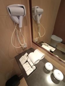 bagno con telefono, lavandino e servizi igienici di Swiss-Belresidences Kalibata a Giacarta