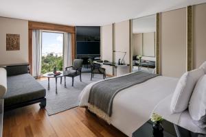 a hotel room with a bed and a desk at The Sukhothai Bangkok in Bangkok