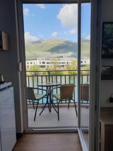 een keuken met een balkon met een tafel en stoelen bij Trebisnjica in Trebinje