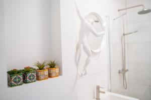 - une salle de bains avec une statue de femme dans une douche dans l'établissement Ginny's studio op de Grote Markt, à Breda