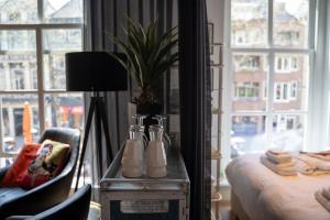 - une chambre avec une table et une plante en pot dans l'établissement Ginny's studio op de Grote Markt, à Breda