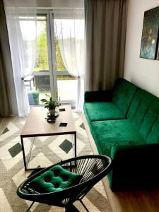 uma sala de estar com um sofá verde e uma mesa em Apartament na Skrzypka em Cieszyn