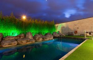 una piscina con illuminazione verde accanto a un edificio di Hotel Puerta de Bilbao a Barakaldo