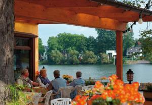 Un groupe de personnes assises à une table près de l'eau dans l'établissement Hotel Weinhaus Kreuter, à Coblence