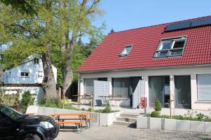 a house with a red roof and a picnic table at Landgasthof Heerlein in Bamberg