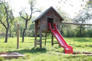 a playground with a slide and a play house at Landgasthof Heerlein in Bamberg