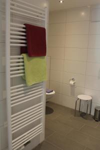 a bathroom with towels and a toilet and a stool at Landgasthof Heerlein in Bamberg