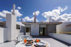 patio con mesa y sillas en el balcón en Ericeira Panoramic Sea View Apartments, en Ericeira