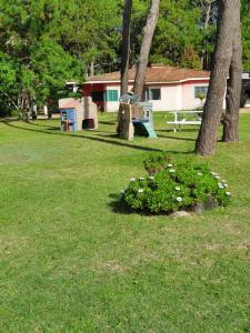 een park met bomen en bloemen in het gras bij Complejo Turistico Chuy in Barra del Chuy