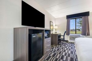 リッチモンドにあるClarion Pointe Richmond North near Universityの薄型テレビ、ベッドが備わるホテルルームです。