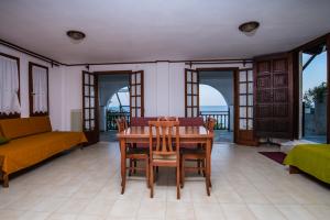 een eetkamer met een tafel en stoelen en een bank bij Beach house Chorefto in Chorefto