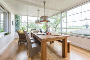 una sala da pranzo con tavolo in legno e finestre di Fährhauslodges Natur in Sicht a Norden