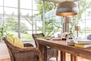 una sala da pranzo con tavolo, libri e sedie di Fährhauslodges Natur in Sicht a Norden