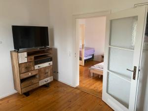 a living room with a television on a wooden dresser at Ferienwohnungen Jakobsberg in Bamberg