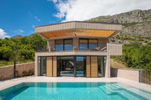 una casa con piscina di fronte a una casa di Palazzo Vimbula - Five Star Luxury Villa a Mokošica