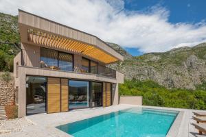 una casa con piscina accanto a una montagna di Palazzo Vimbula - Five Star Luxury Villa a Mokošica