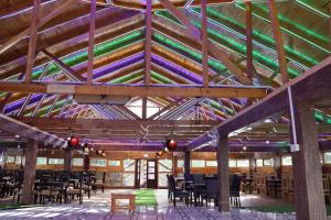 a room with a wooden ceiling with tables and chairs at Hotel Al Azeem in Ayubia