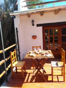 uma mesa de madeira e cadeiras num deque em Hosteria La Estacion em Tilcara