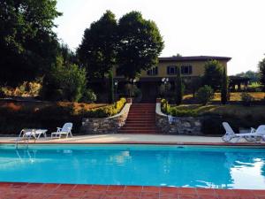 una piscina con 2 sillas y una casa en Lucca Cycling Holidays Il Tiglio Rooms, en Lucca