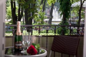 een fles champagne zittend op een tafel met een bloem bij City Garden Apartments in Odessa