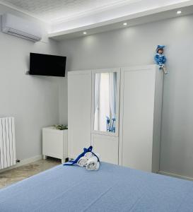 una camera con letto blu e TV a parete di Casa Torrese a Torre del Greco