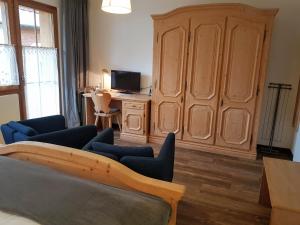 ein Wohnzimmer mit einem großen Holzschrank und einem Schreibtisch in der Unterkunft Hotel Beau-Séjour in Leukerbad