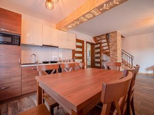 een keuken en eetkamer met een houten tafel en stoelen bij Tatrzańska Kryjówka Premium Chalets Zakopane in Poronin