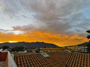 a view of the sunset from the roof of a building at Hotel Posada San Pedro in Antigua Guatemala