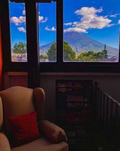 a chair in a room with a view of a mountain at Hotel Posada San Pedro in Antigua Guatemala